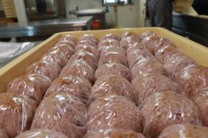 金ゴマをのせ、ラップにくるまれたいがまんじゅう