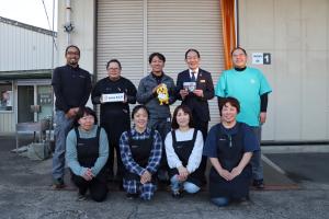 小林社長と社員の皆さんと一緒に記念撮影する様子