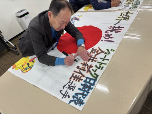 日の丸にメッセージを記入する並木市長