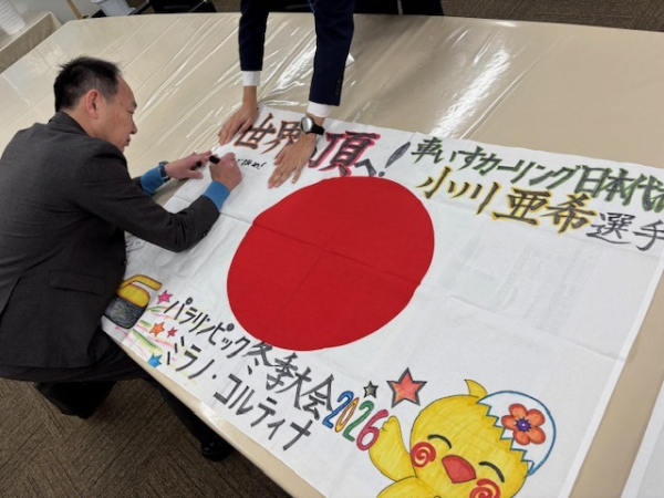 日の丸にメッセージを記入する並木市長