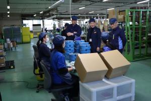 商品を梱包する社員の皆さんと話す市長