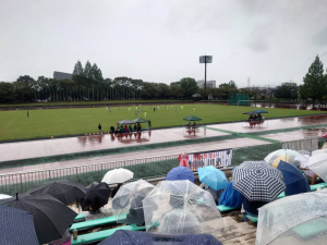 雨の中、多くの人が観戦する様子