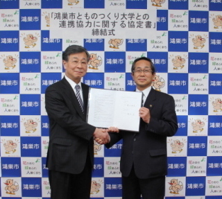 協定書を持つものつくり大学の稲永忍学長と原口市長