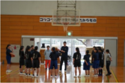 生徒が集合してコーチの話を聞いている写真