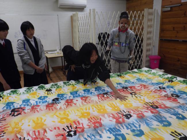 手形のアート体験をしている中学生