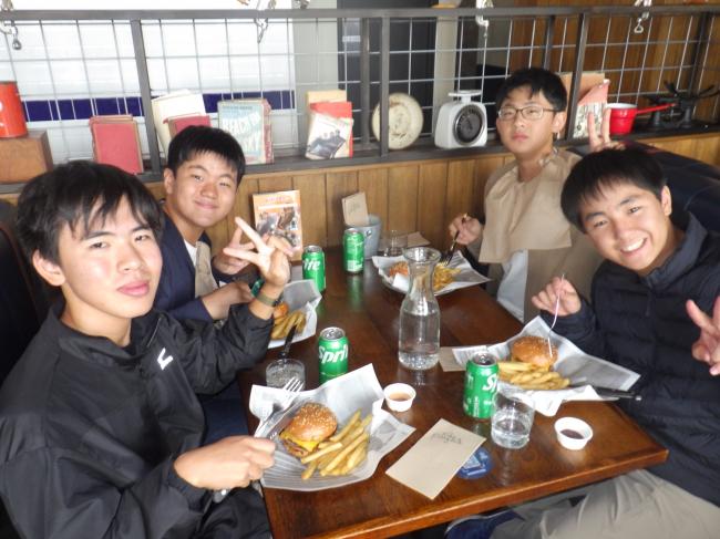 大きなハンバーガーを食べる中学生