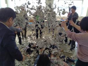 パパとこどもが新聞びりびりで実践的に遊んでいる写真