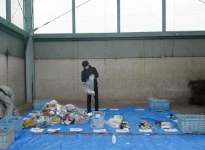 職員がごみ袋の中身を分別する様子の写真