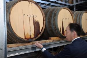 樽から染み出る原酒に触れる市長