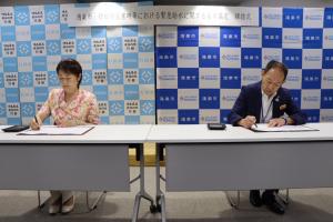協定書に署名する両市長